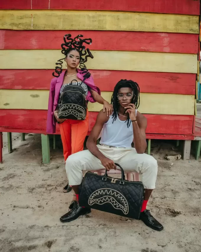 Bolsa de lona negra acolchada con cadena dorada y diseño de tiburón